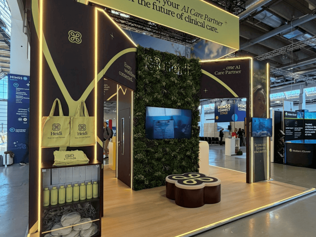 Healthcare exhibition booth with green wall and digital screens at Southall and Rush.